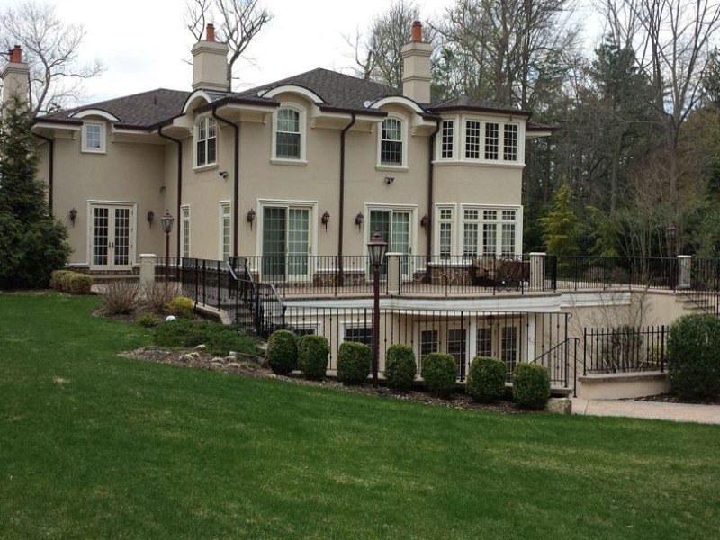 A large white house with a green lawn in front of it.