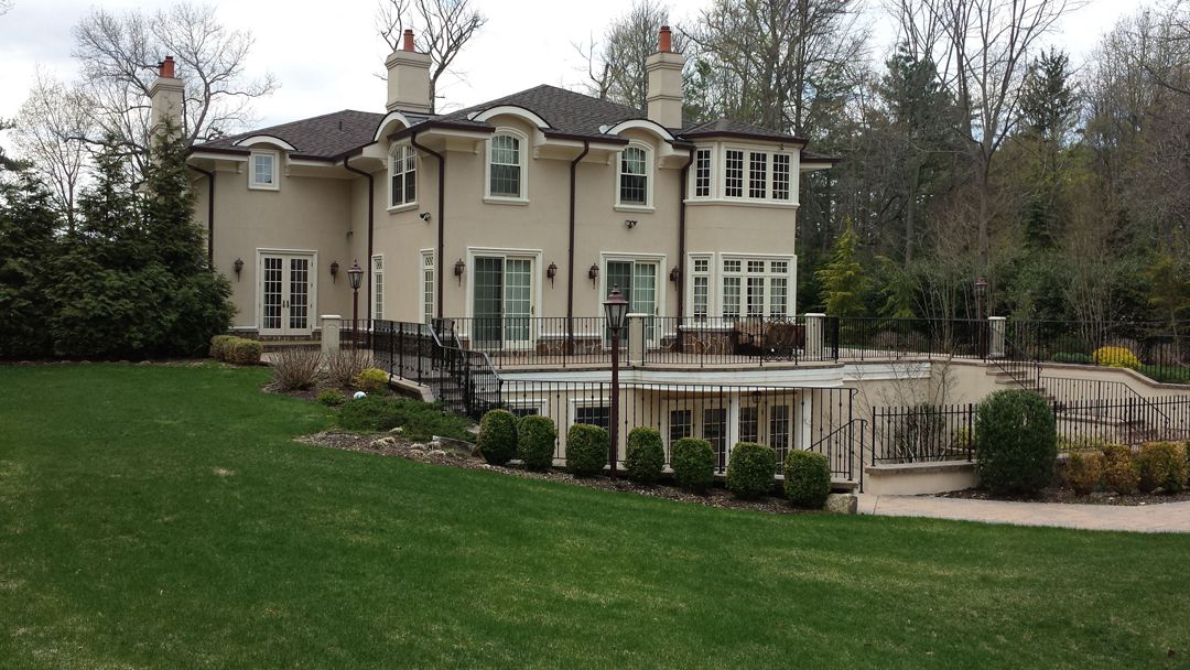 A large white house with a green lawn in front of it.