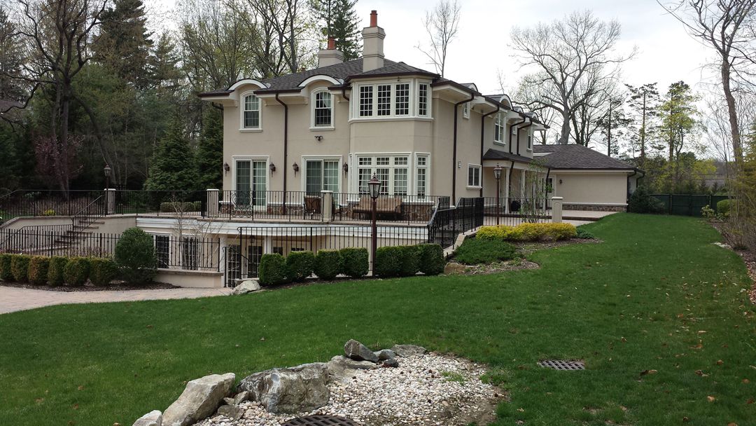 A large white house sitting on top of a green hillside.