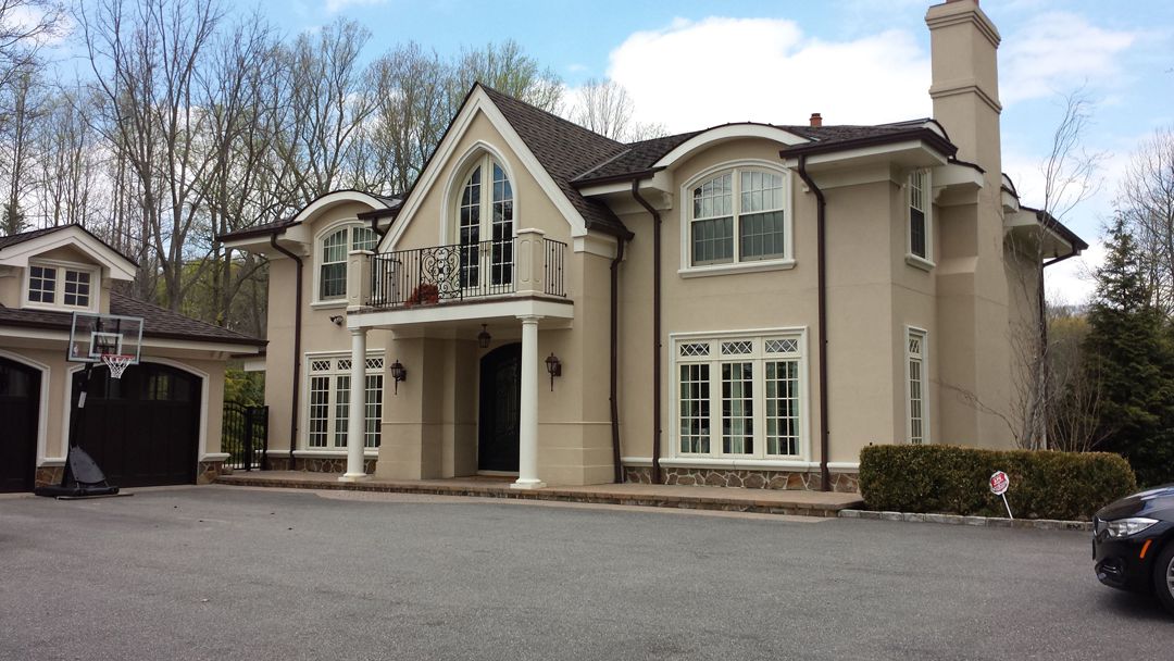 A large white house with a balcony on the front.