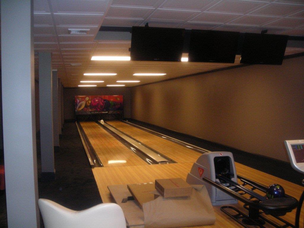 A bowling alley with a couch and chair in it