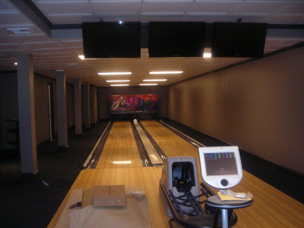 A bowling alley with a table and a computer.