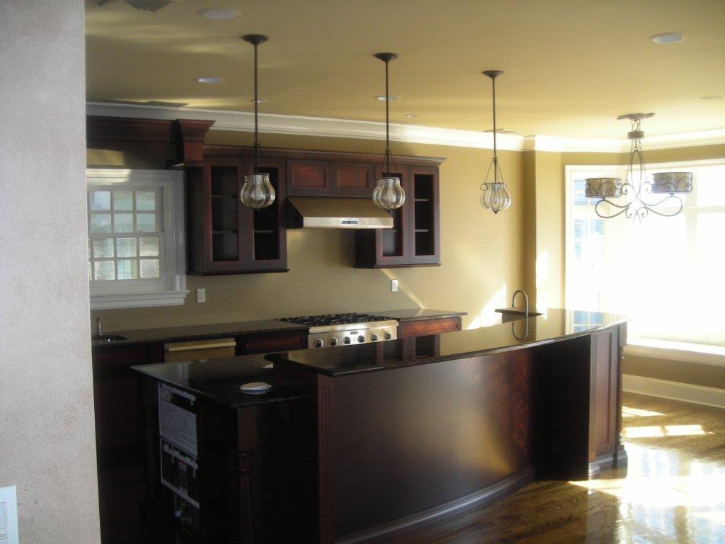 A kitchen with dark wood cabinets and light brown walls.