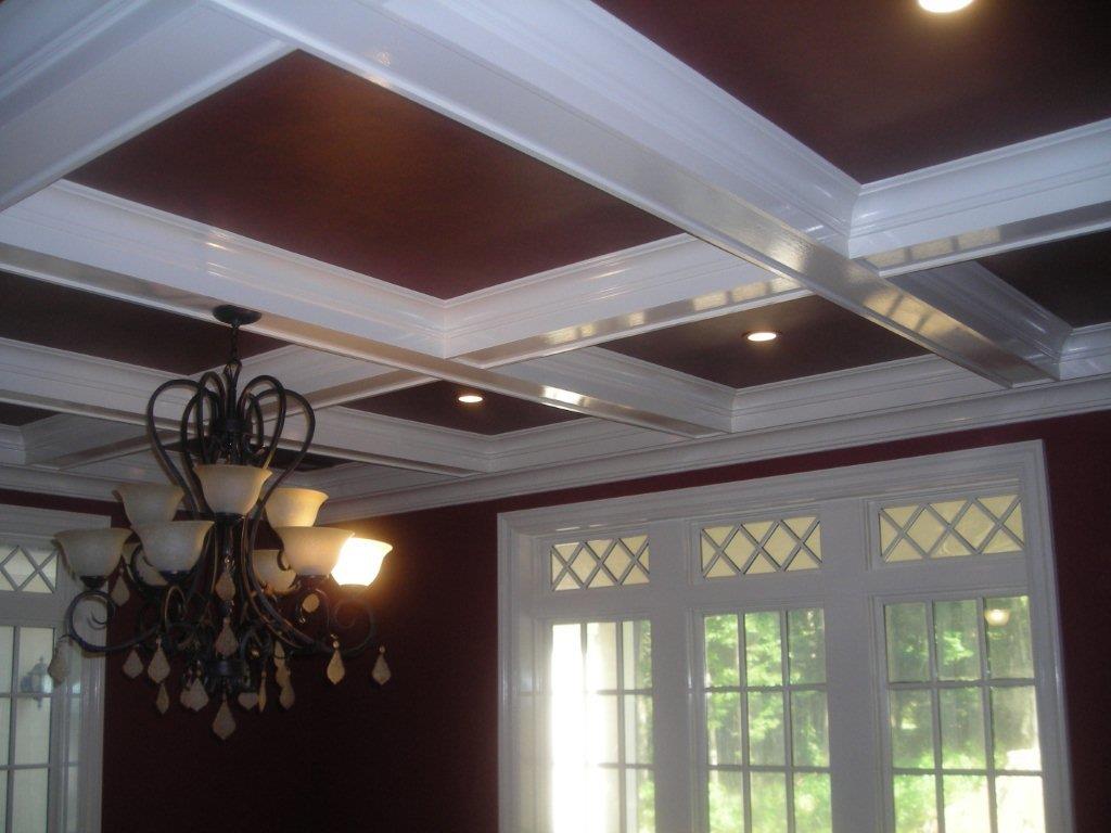 A chandelier in the center of a room with windows.