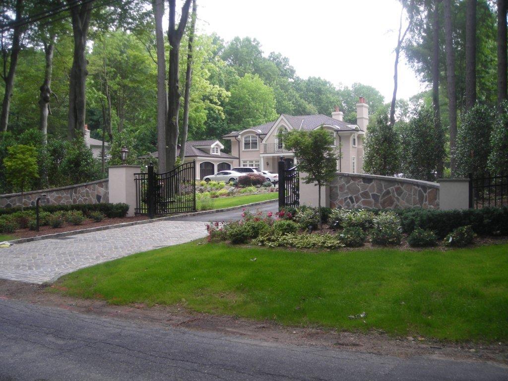 A driveway with grass and trees in the background.