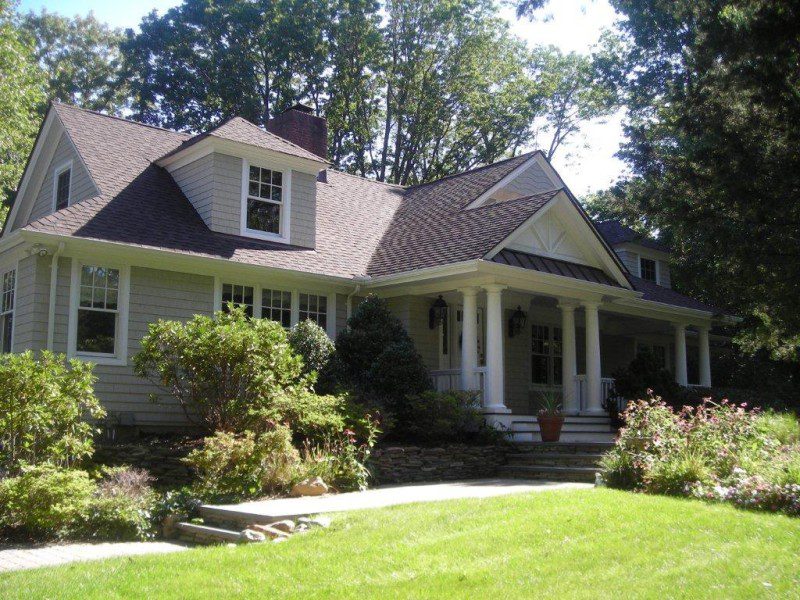 A large house with a lawn and trees in the background.