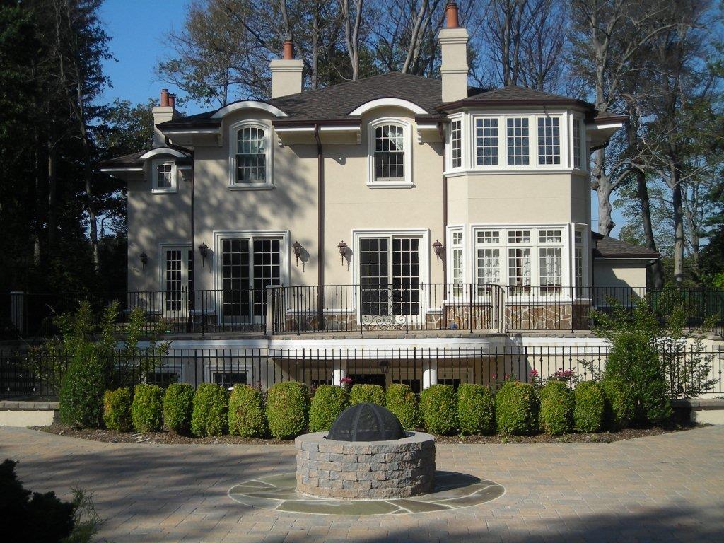 A large white house with a fire pit in the middle of it.