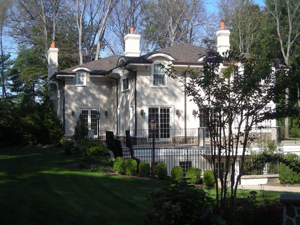 A large white house with trees in the background.