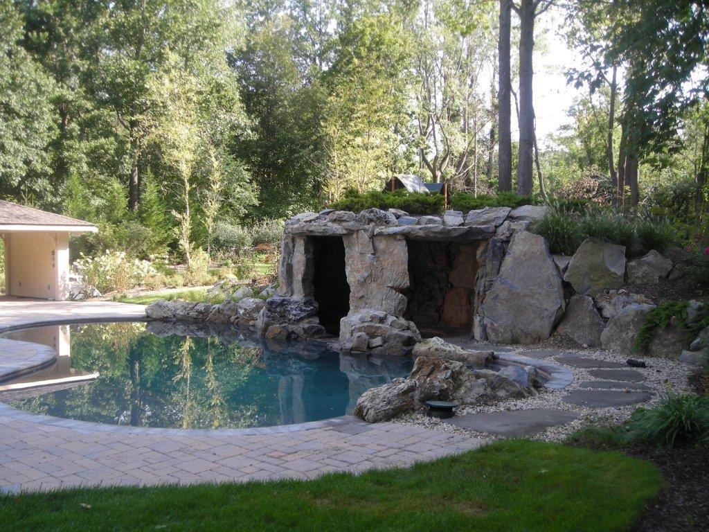 A pool with rocks and trees in the background