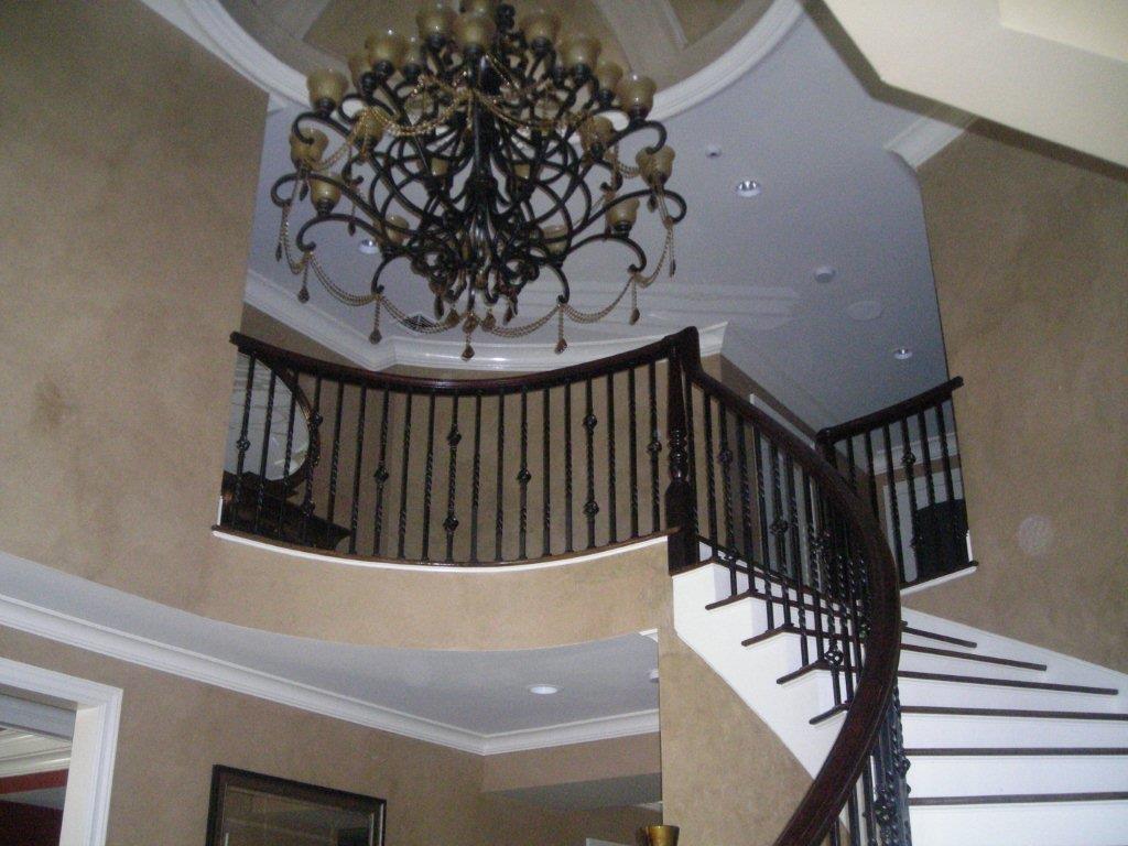 A chandelier and staircase in the center of a room.