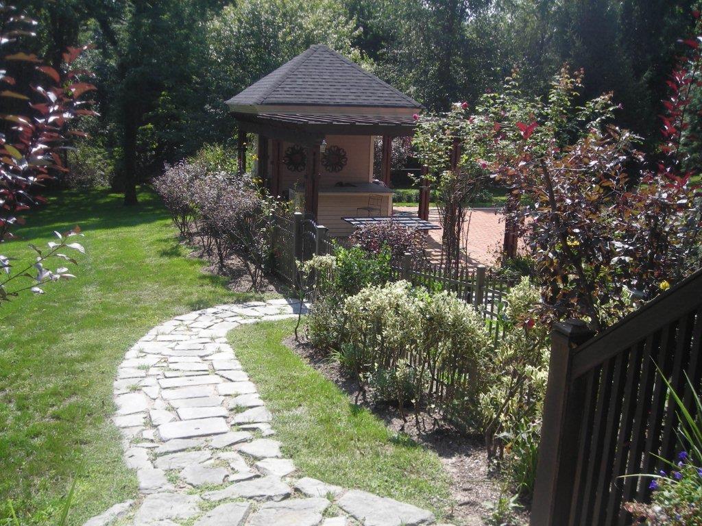 A garden with a gazebo and a path in the middle of it.