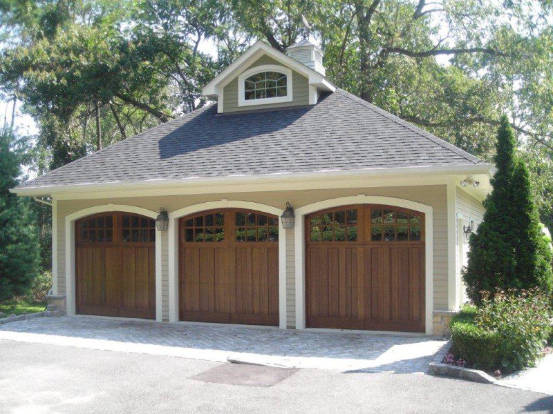 A three car garage with wood doors and windows.