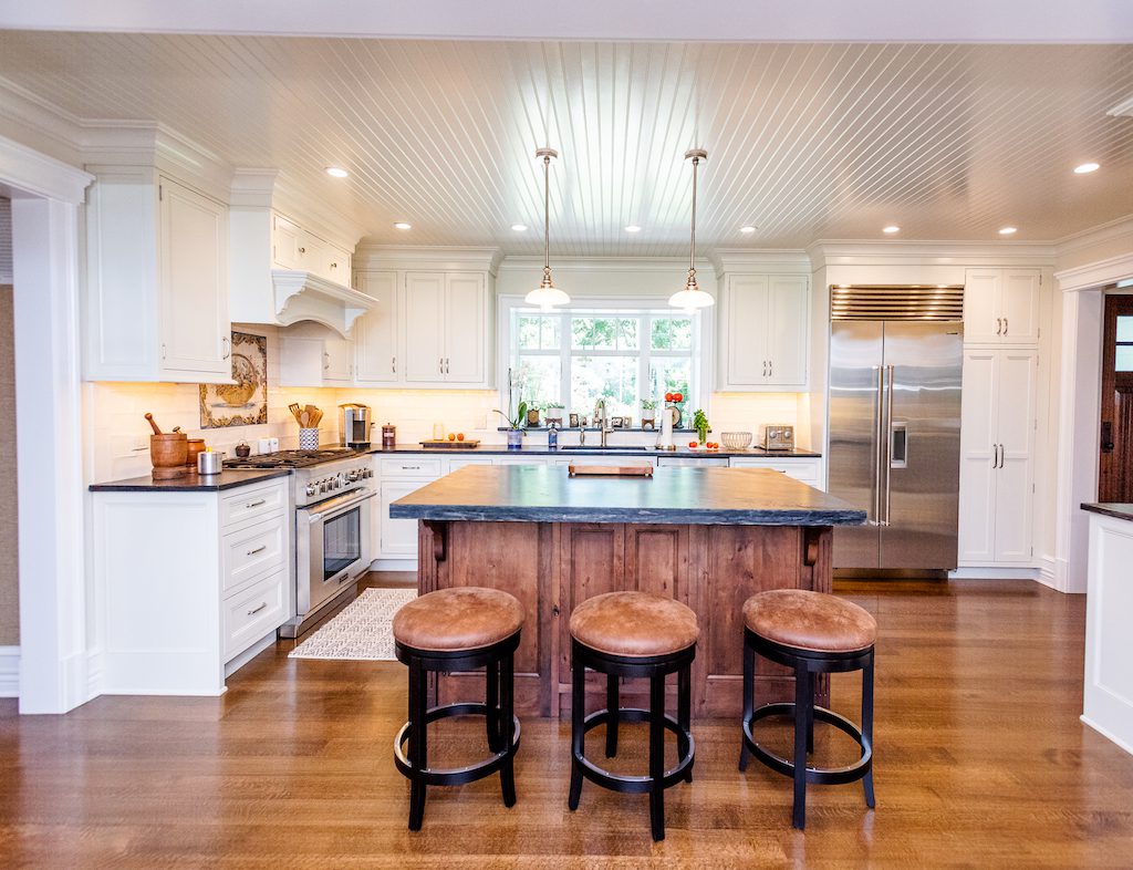A kitchen with three stools in it
