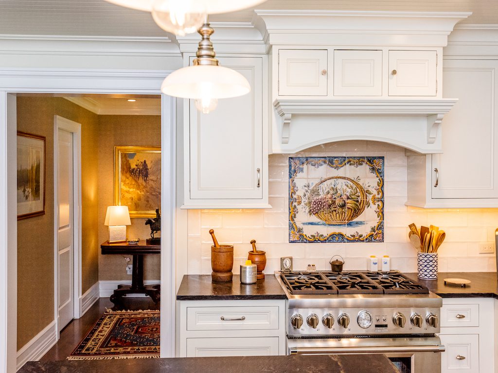 A kitchen with white cabinets and a stove.